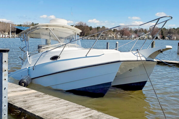 sinking white catamaran boat in boat slip