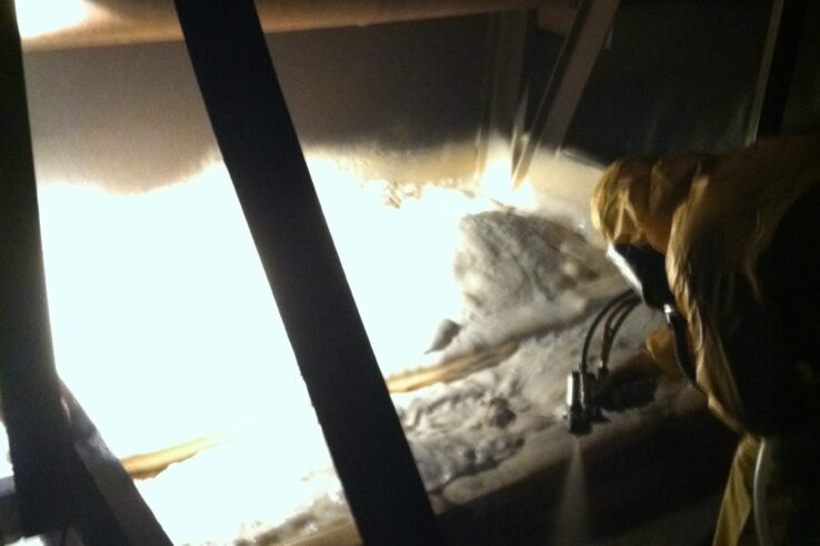 Builder installing spray foam insulation